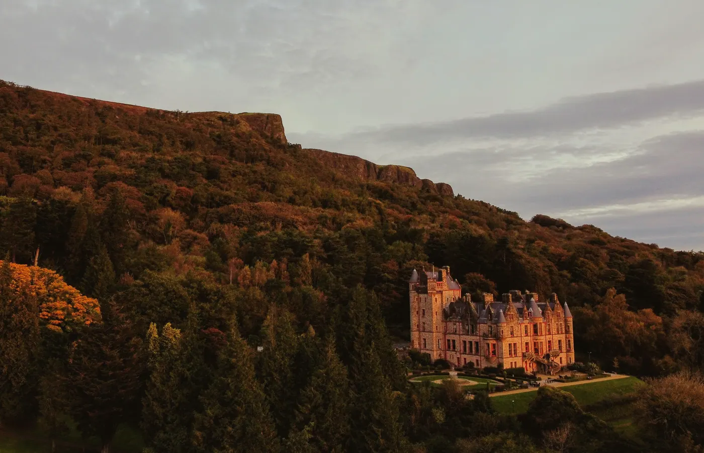 A castle and wooded hillside photographed from the air